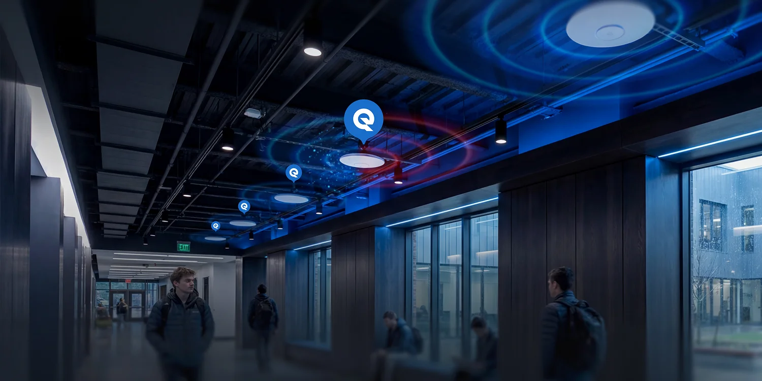 Students walking through a building corridor with a row of ceiling Wi-Fi access points emitting blue signal rings